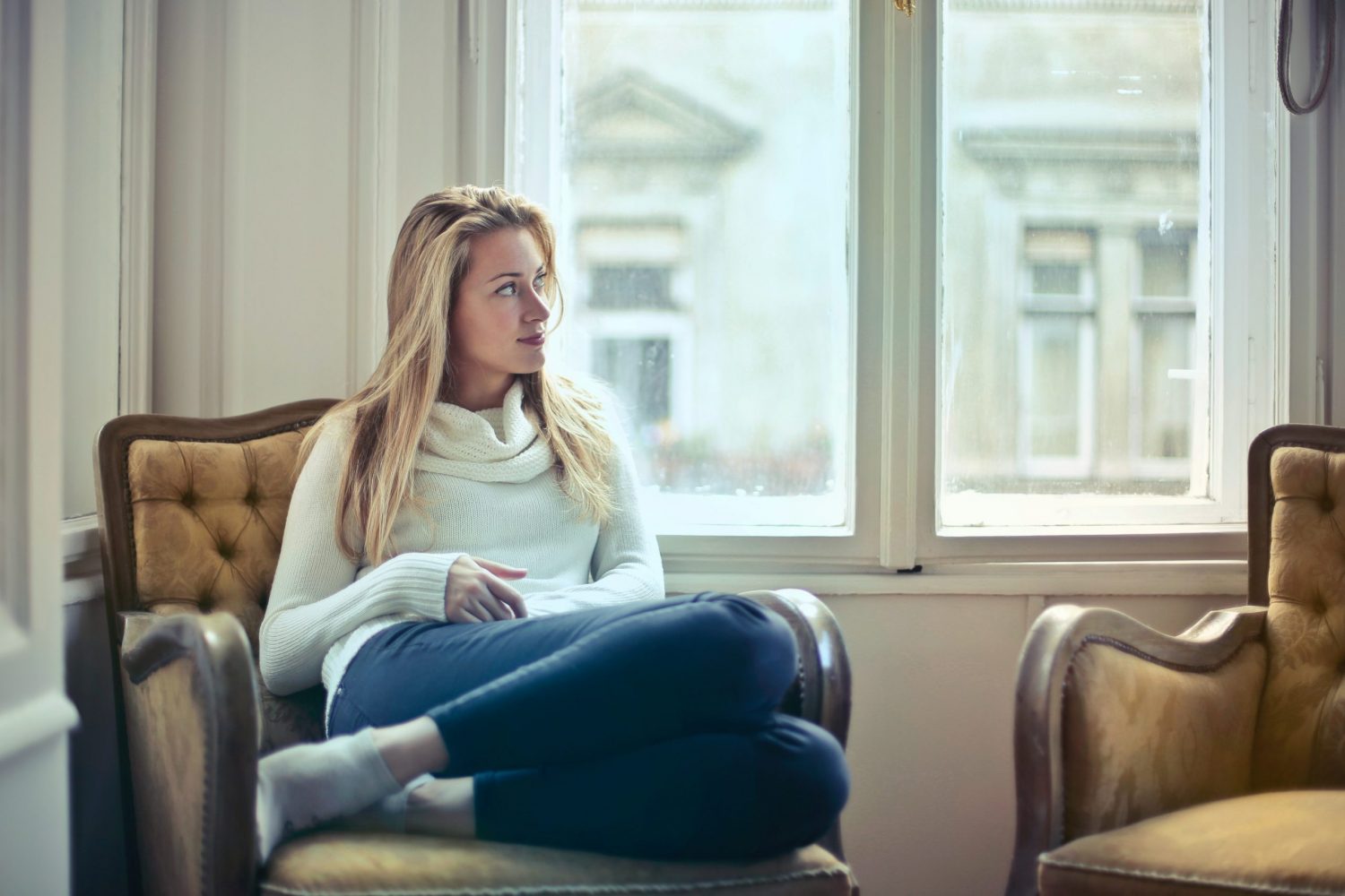Image of woman sitting in chair, staring out window